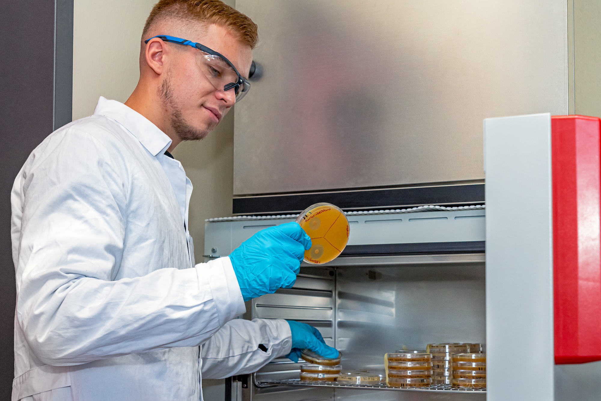 Junger Mann steht im Chemie-Labor