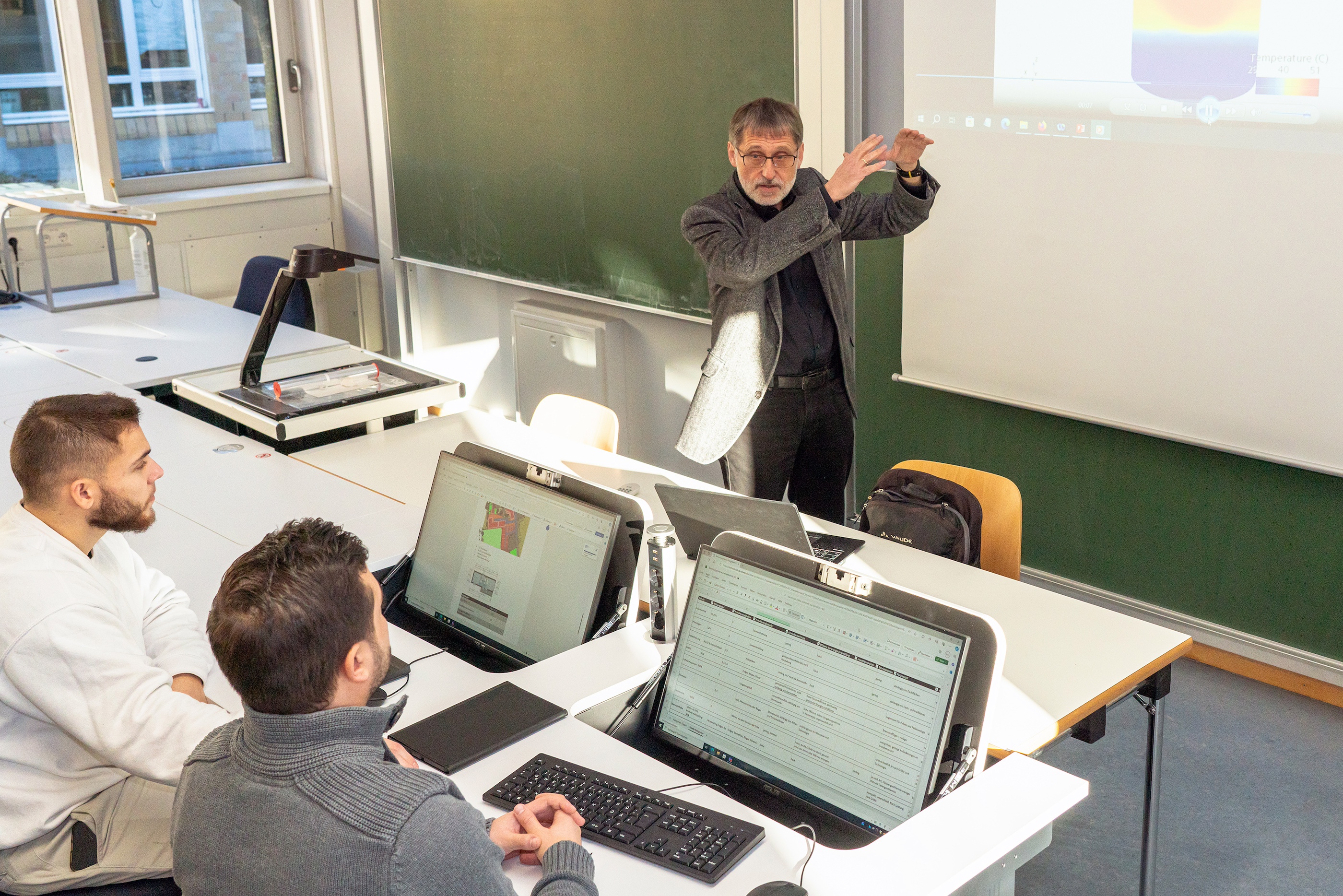 Studierende sitzen in Labor mit hochmodernen Schreibtischen
