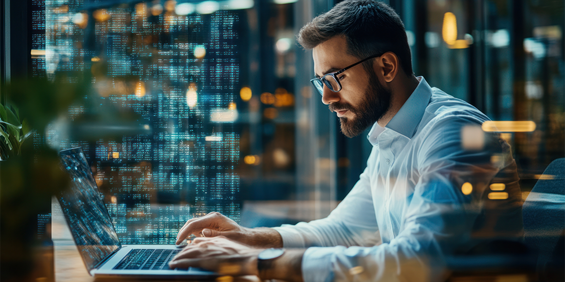 Modern und smart gekleideter Immobilienmakler sitzt in modernem Büro am Schreibtisch mit Laptop