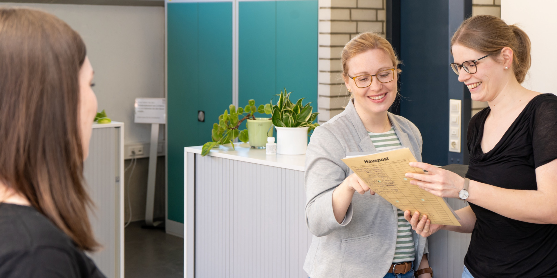 Drei Frauen stehen in einem Büro