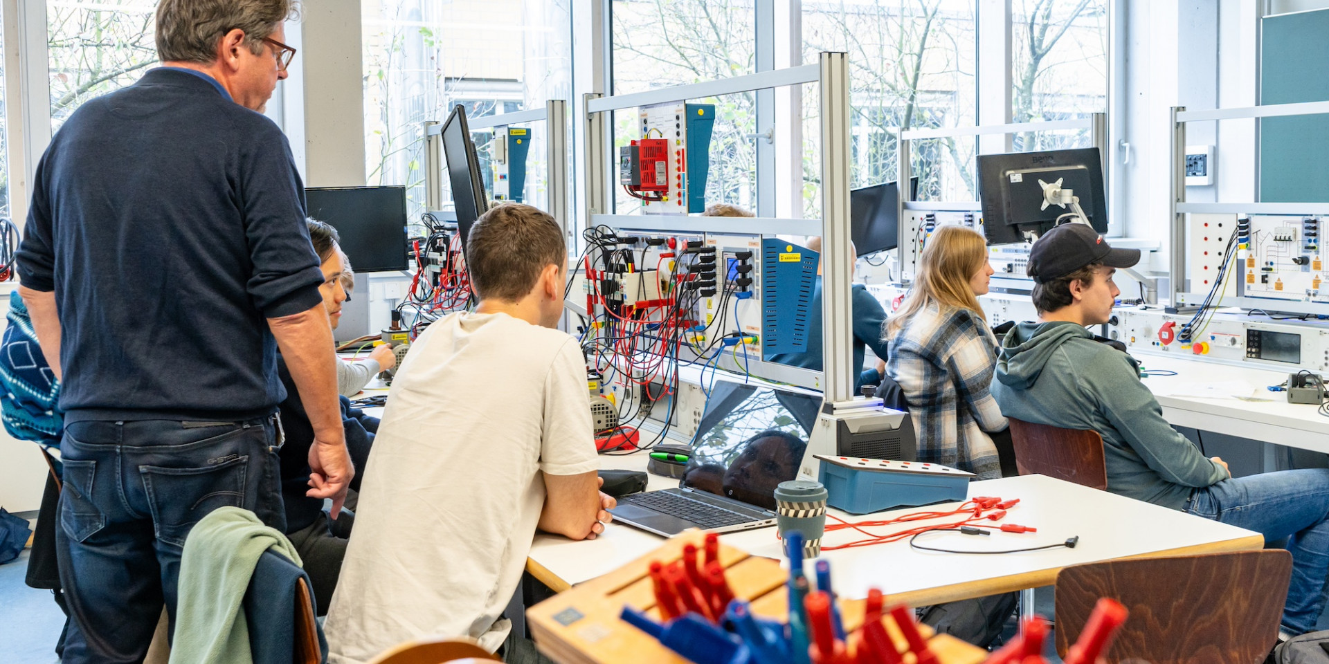 Personen sitzen in einem Labor für elektrische Systeme