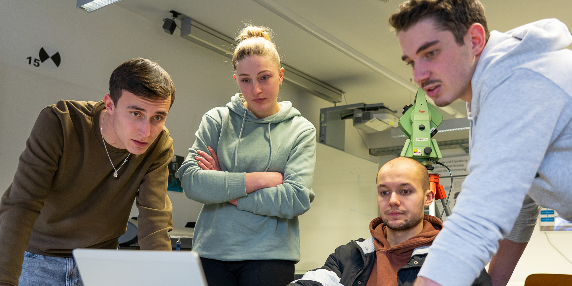 Vier Studierende arbeiten an einem Laptop