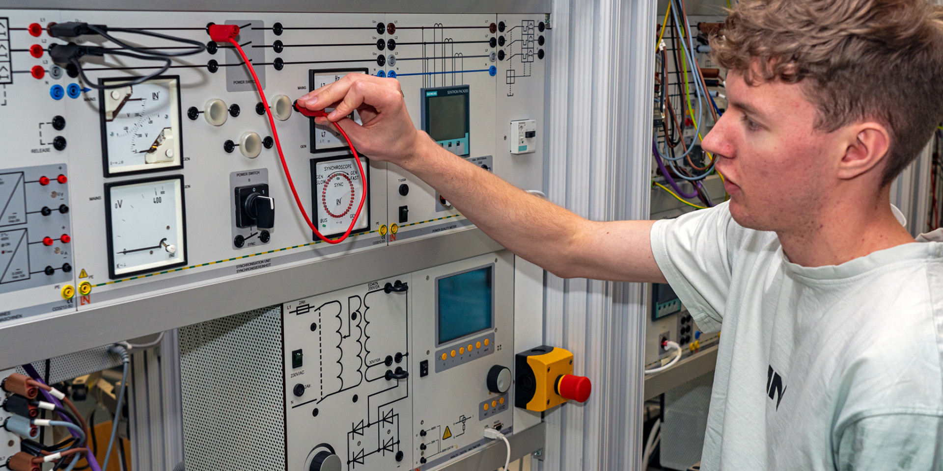 Studierender Jens Hagmeyer steht vor Modell Netzsynchronisation im Labor für Elektrische Systeme
