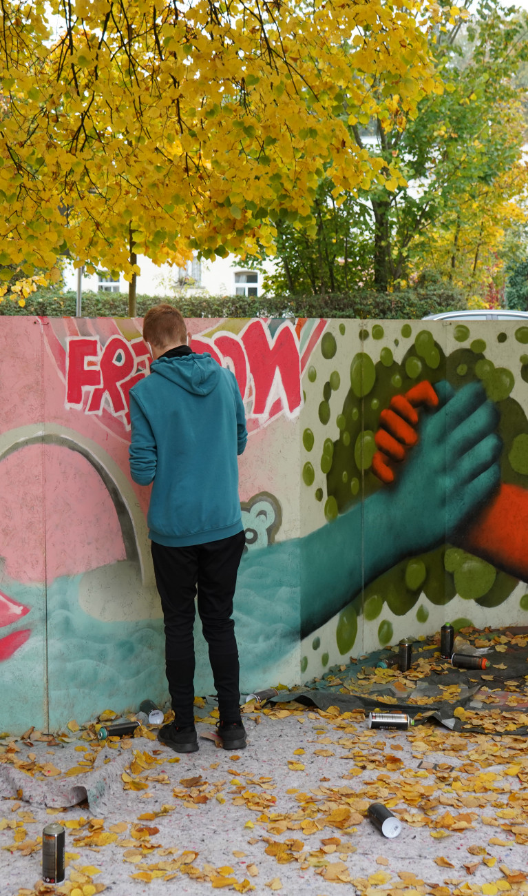 Mann von hinten beim Graffiti sprühen
