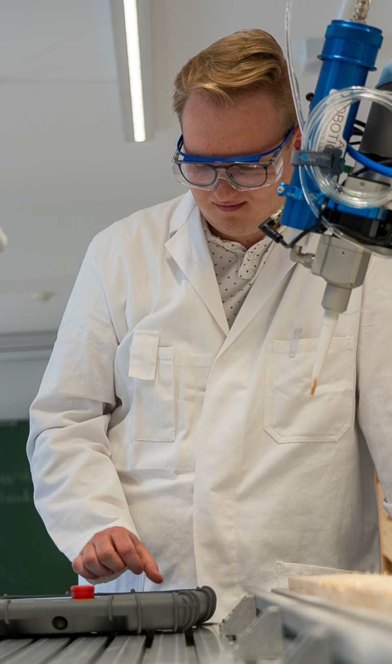 Zwei Männer im Labor arbeiten an einem Roboterarm