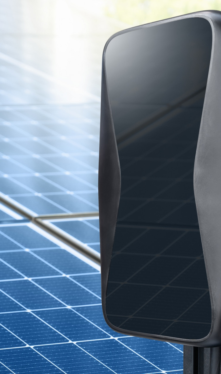 Ladestation und PV-Anlage im Hintergrund