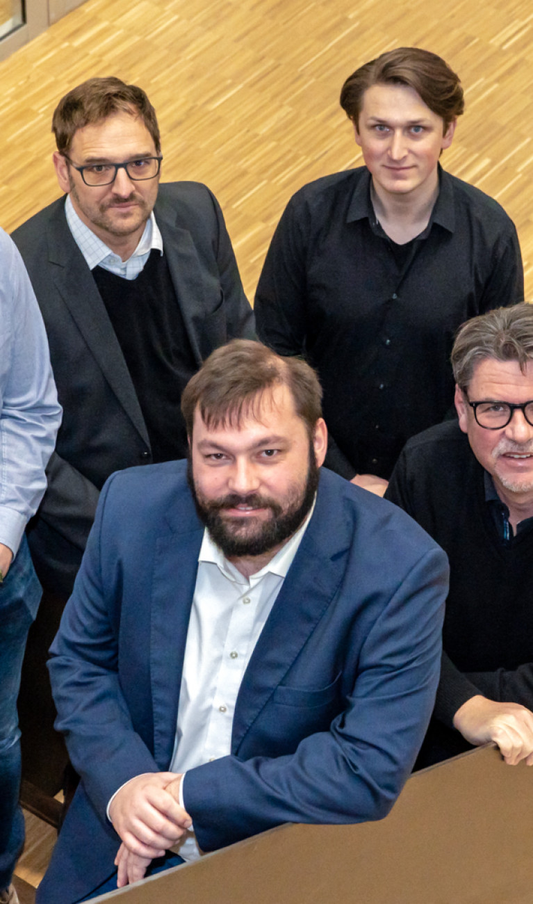 Sechs Personen stehen auf einer Treppe