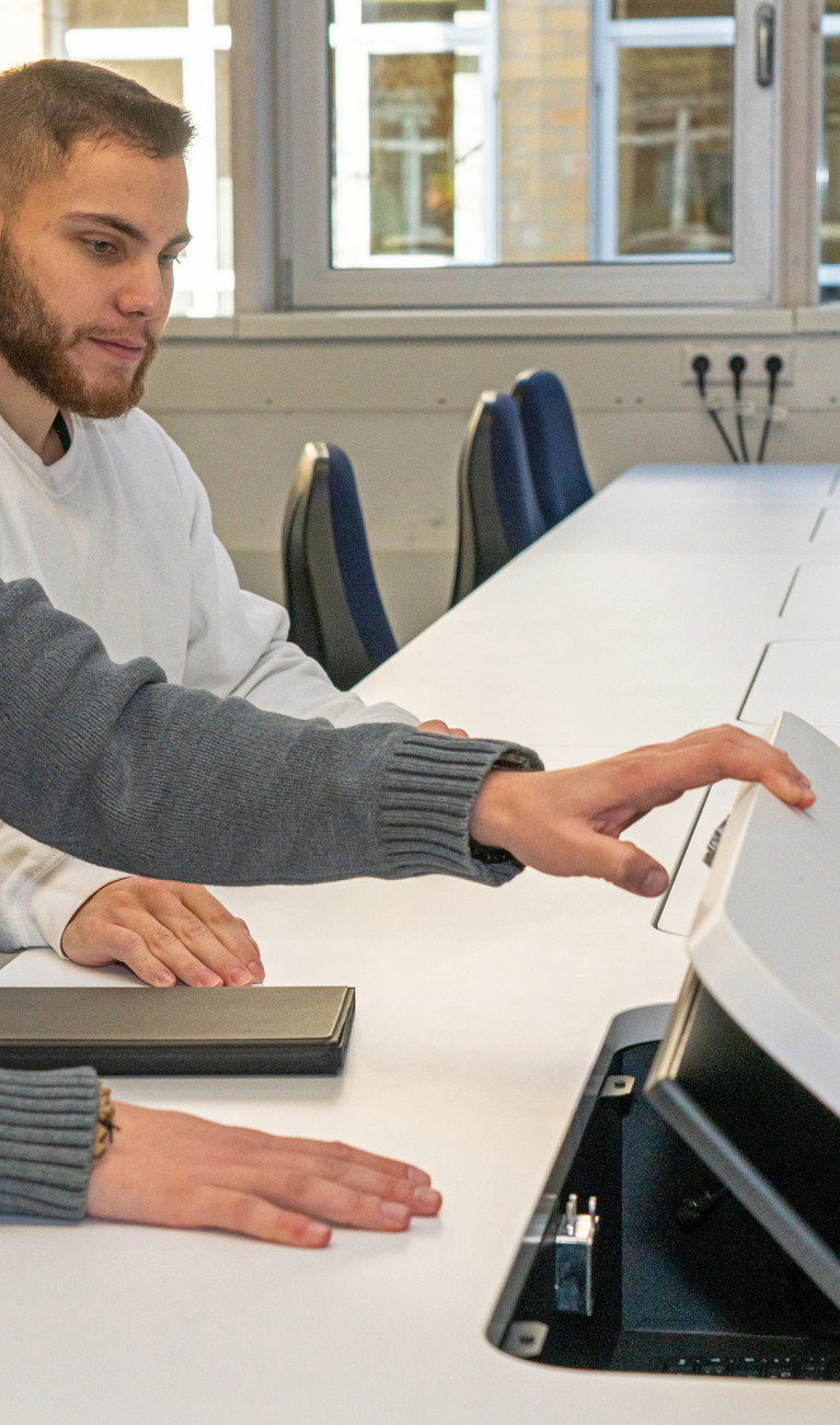 Student sitzt an hochmodernem Schreibtisch 